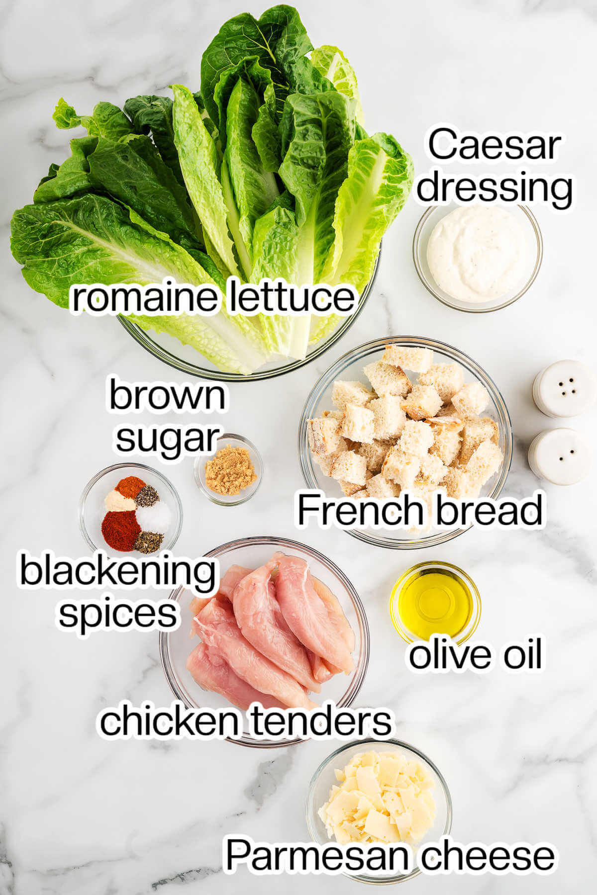 Ingredients for chicken caesar salad on a table.