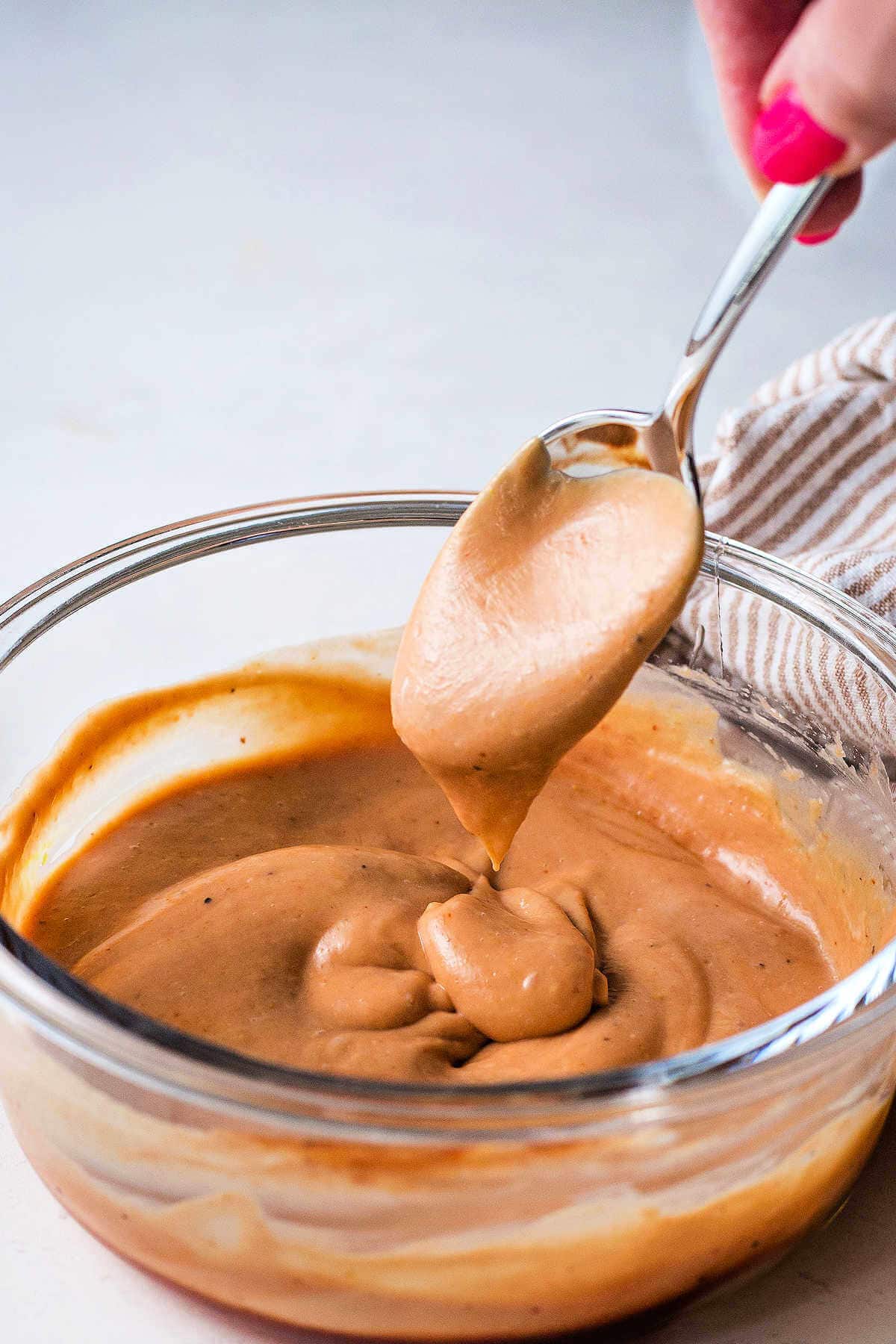 A spoon in a bowl of chick fil-A sauce.
