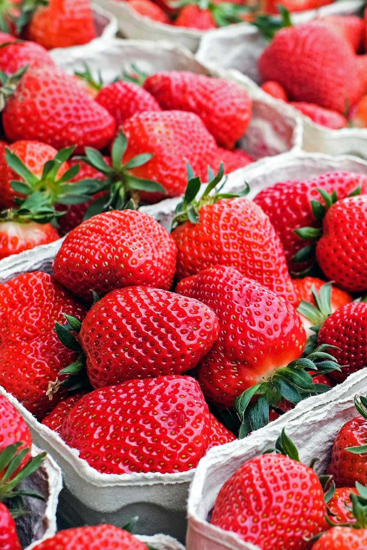 Cartons of fresh strawberries on a table.