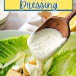 Drizzling Caesar Salad Dressing on top of romaine lettuce.