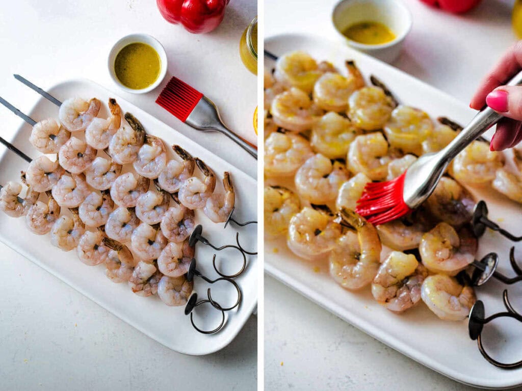 Shrimp on skewers with a hand brushing them with reserved vinaigrette.