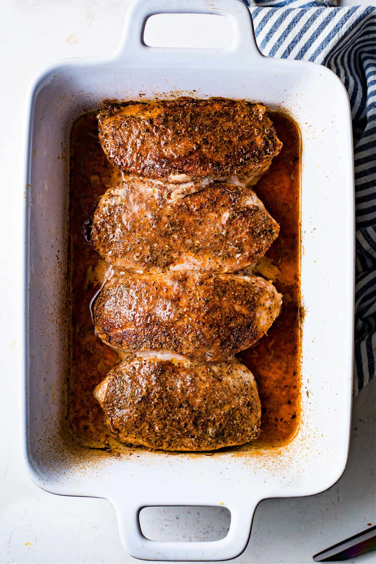 Pork loin chops in the baking dish after being baked.