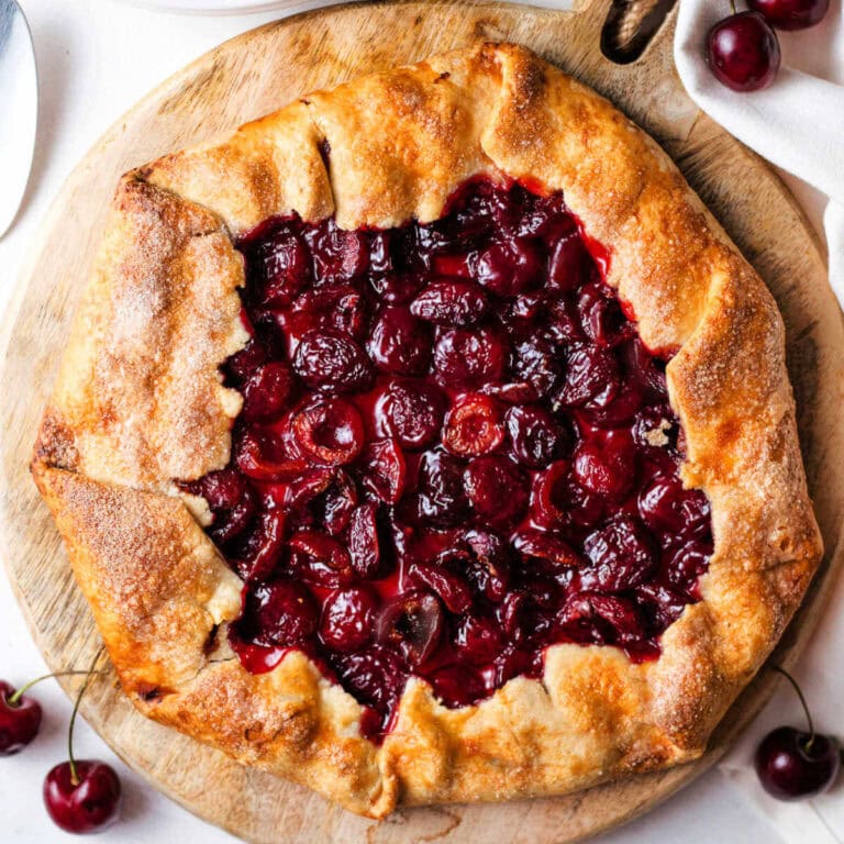 A rustic cherry tart, or cherry galette, on a wooden board.