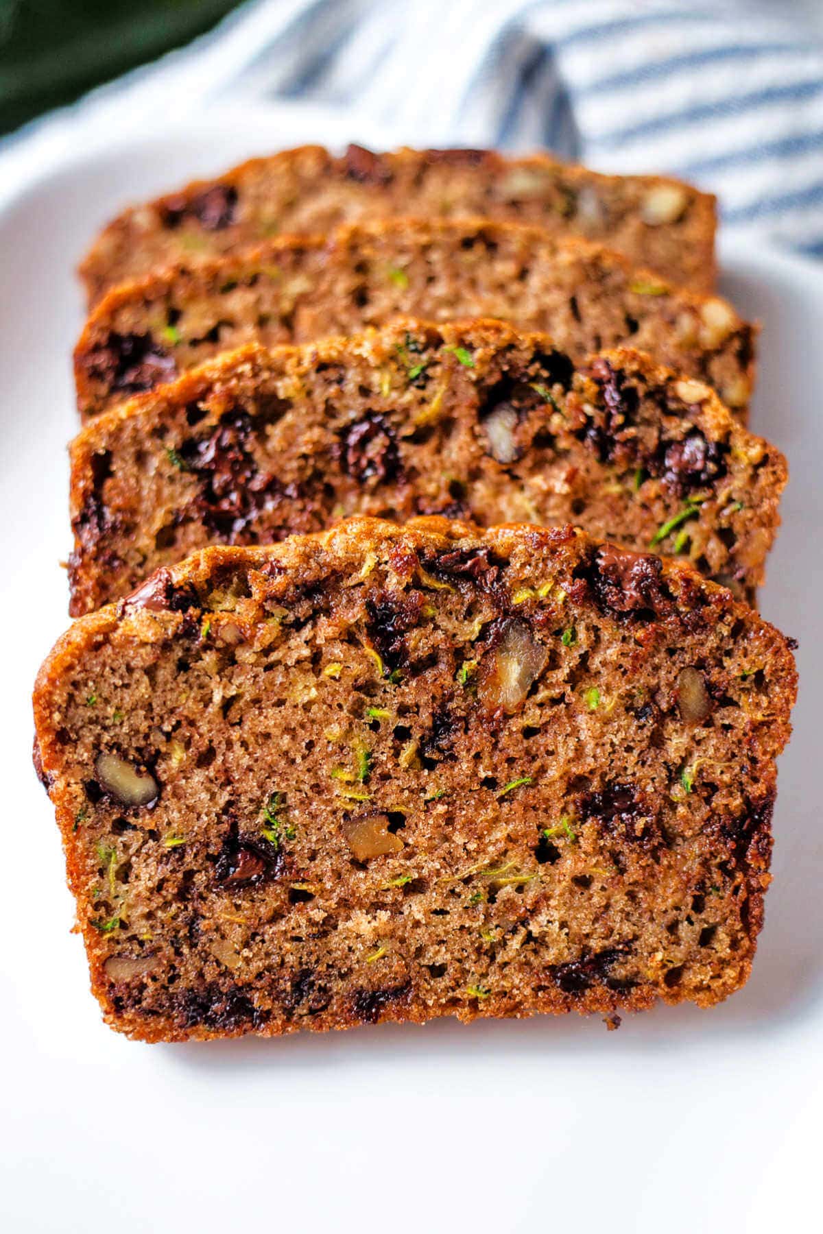 Four slices of chocolate chip zucchini bread leaning on each other.