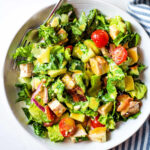 Chopped Chicken Salad in a bowl with chicken, avocado, tomatoes, cucumber, bacon, and homemade honey mustard dressing.