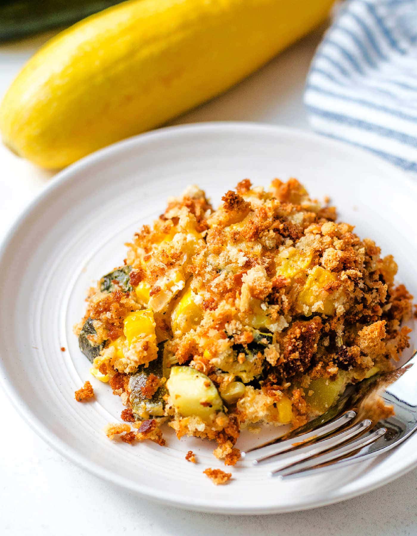 Portion of summer squash casserole on a white plate.