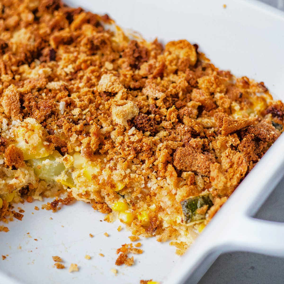 Side view of the summer squash casserole with some missing from the baking dish.