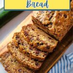 Slices of chocolate chip zucchini bread on a wooden board.