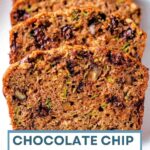 Slices of chocolate chip zucchini bread on a wooden board.