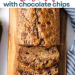 Slices of chocolate chip zucchini bread on a wooden board.