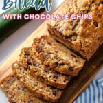 Slices of chocolate chip zucchini bread on a wooden board.