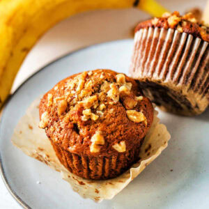 Two banana nut muffins on a plate.