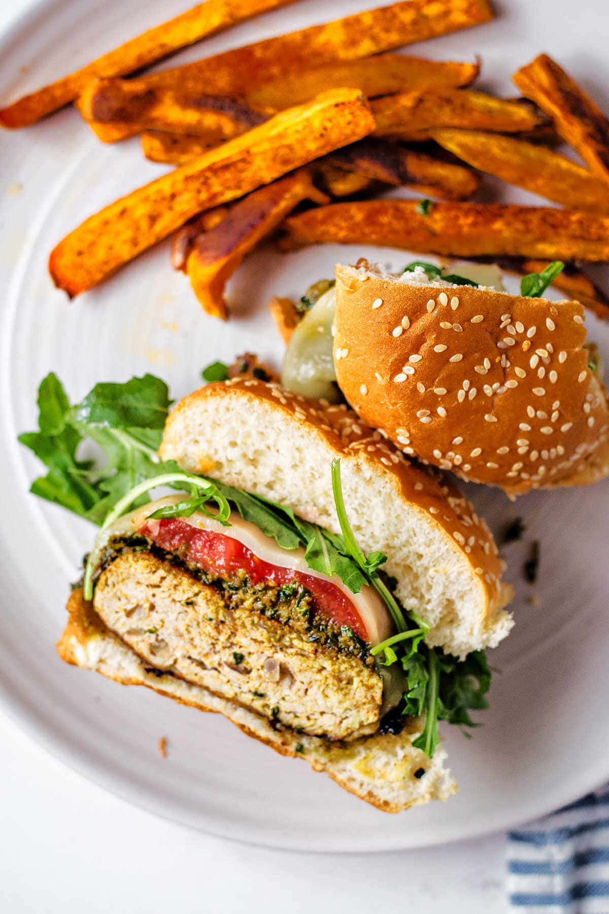 Caprese-style chicken burgets sliced in half to show the layers inside.