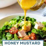 Pouring honey mustard dressing over Chopped Chicken Salad in a bowl.