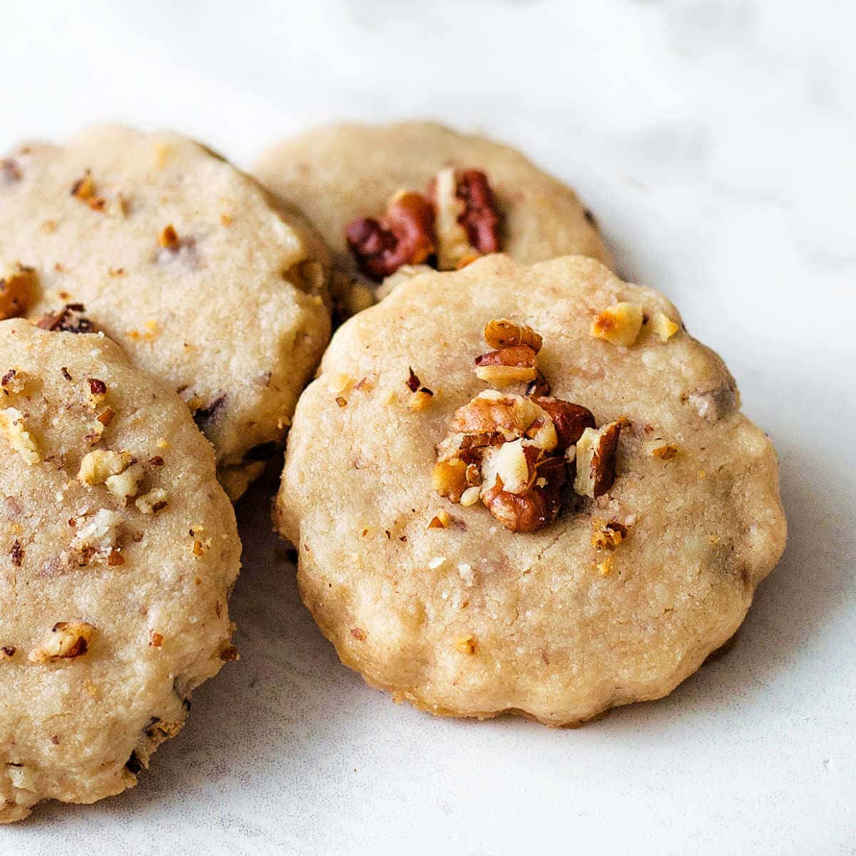 Pecan shortbread cookies stacked on a table.