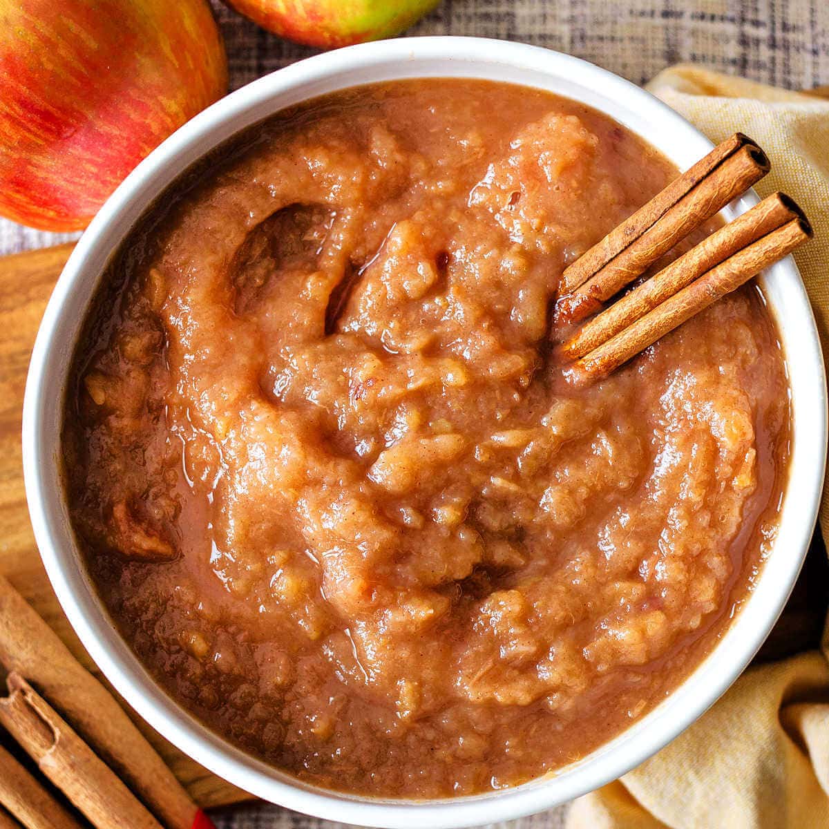Applesauce made in the instant pot in a bowl with cinnamon sticks.