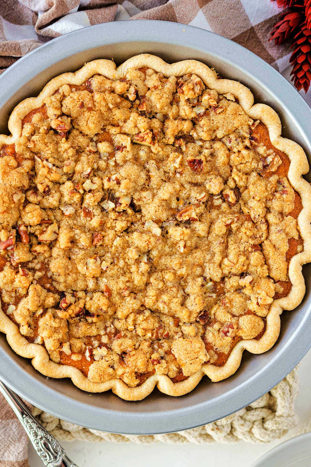 Sweet potato pie in a pie pan with a crumble topping on top.