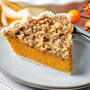 A slice of Sweet Potato Pie on a plate with a fork.