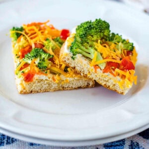 Two square pieces of Cold Veggie Pizza Appetizers on a plate.