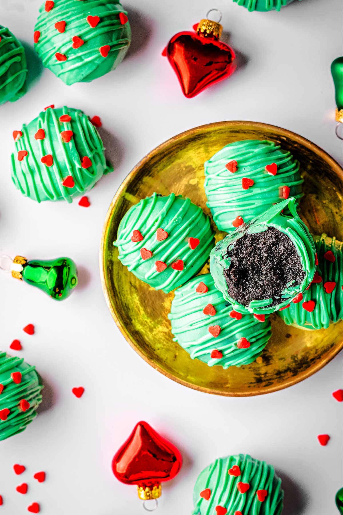 Overhead shot of Christmas Oreo balls on a plate with more scattered around.