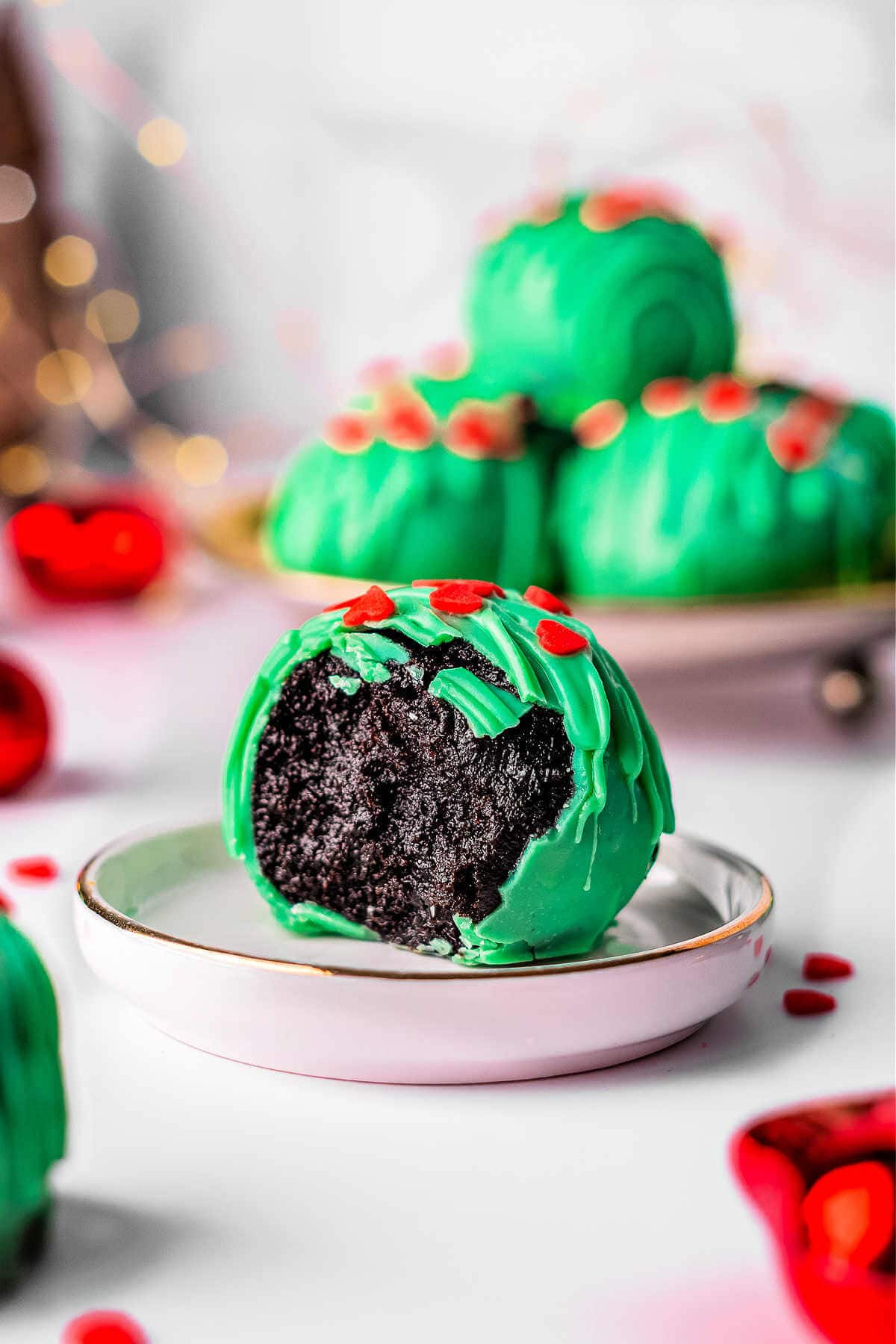 Side view of a Christmas oreo ball with a bite taken out of it.