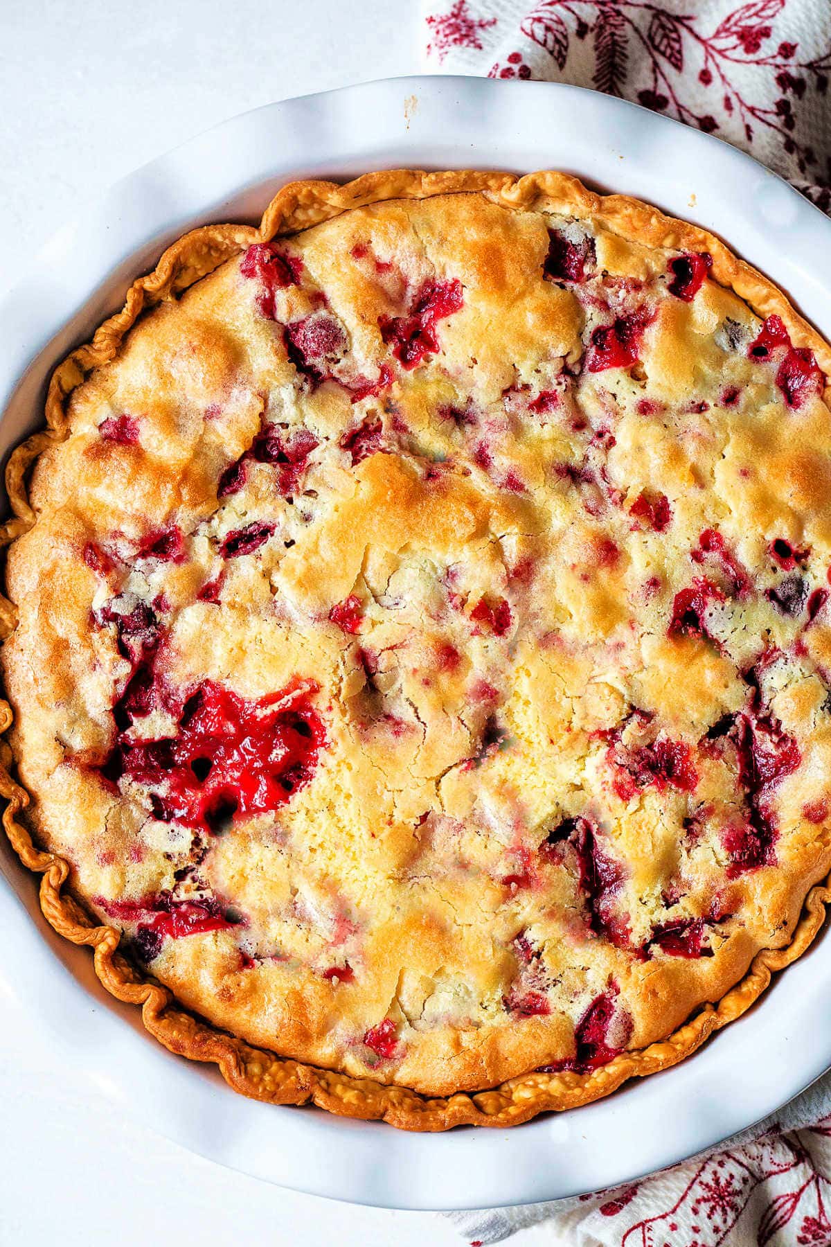 Baked cranberry pie in a white baking dish.