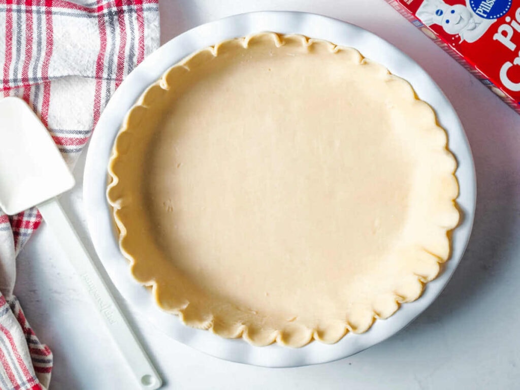 Pie crust pressed into a white pie dish.