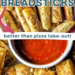 Garlic Breadsticks on a plate with marinara sauce.