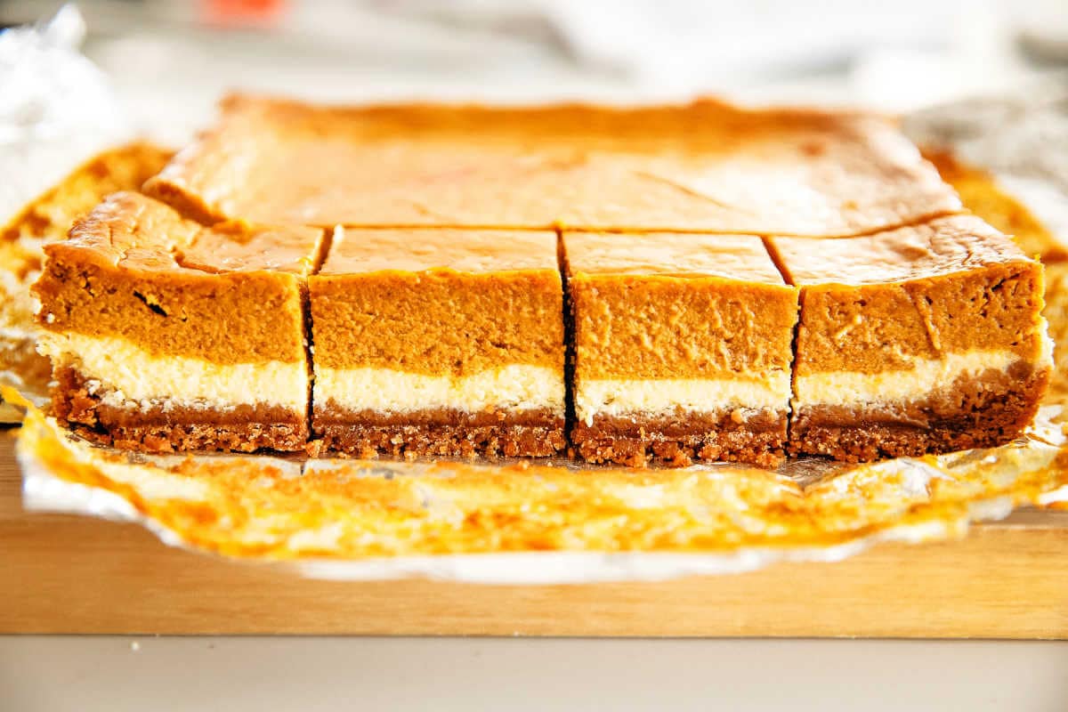 Side view of pumpkin cheesecake bars cut into slices.