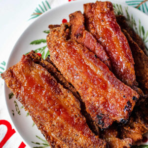 Pieces of candied bacon on a plate.