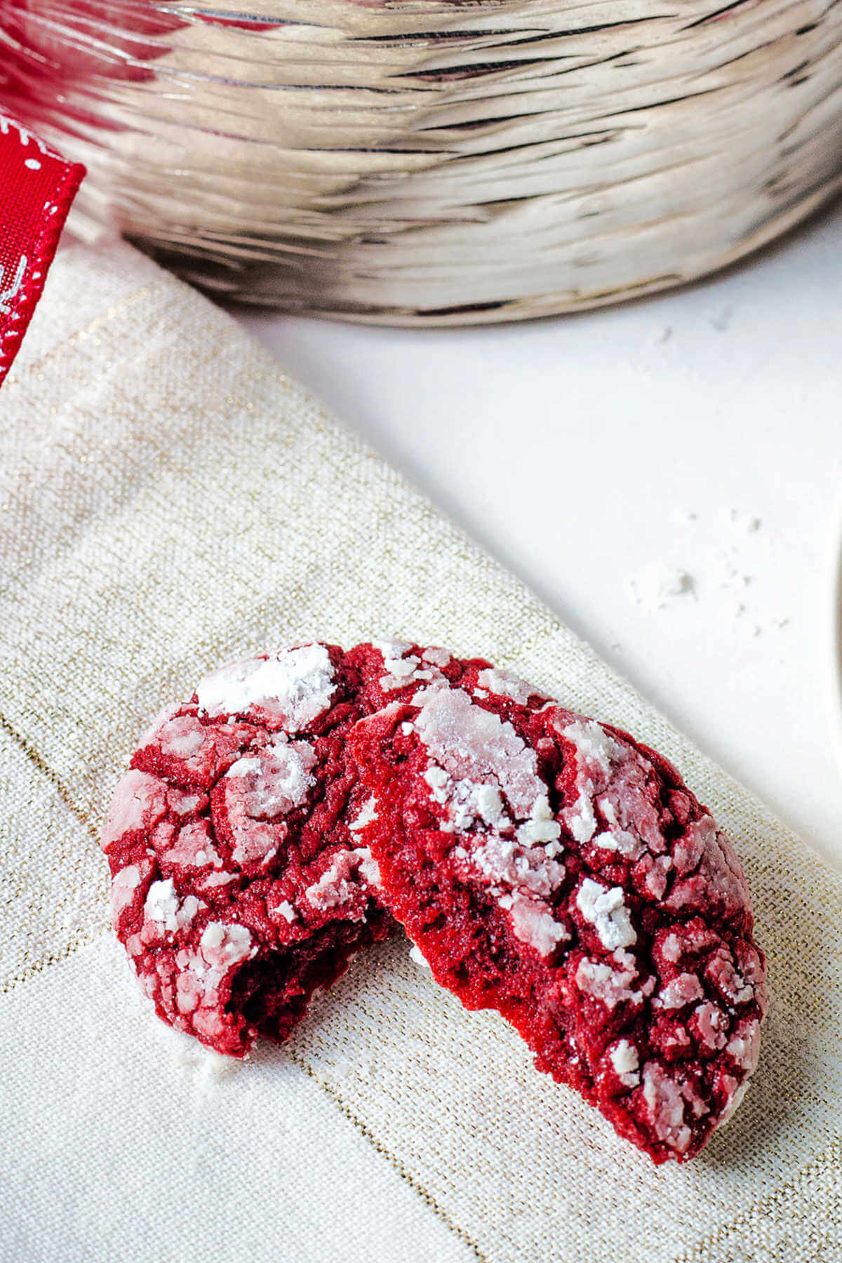 One red velvet cake crinkle cookie broken in half.