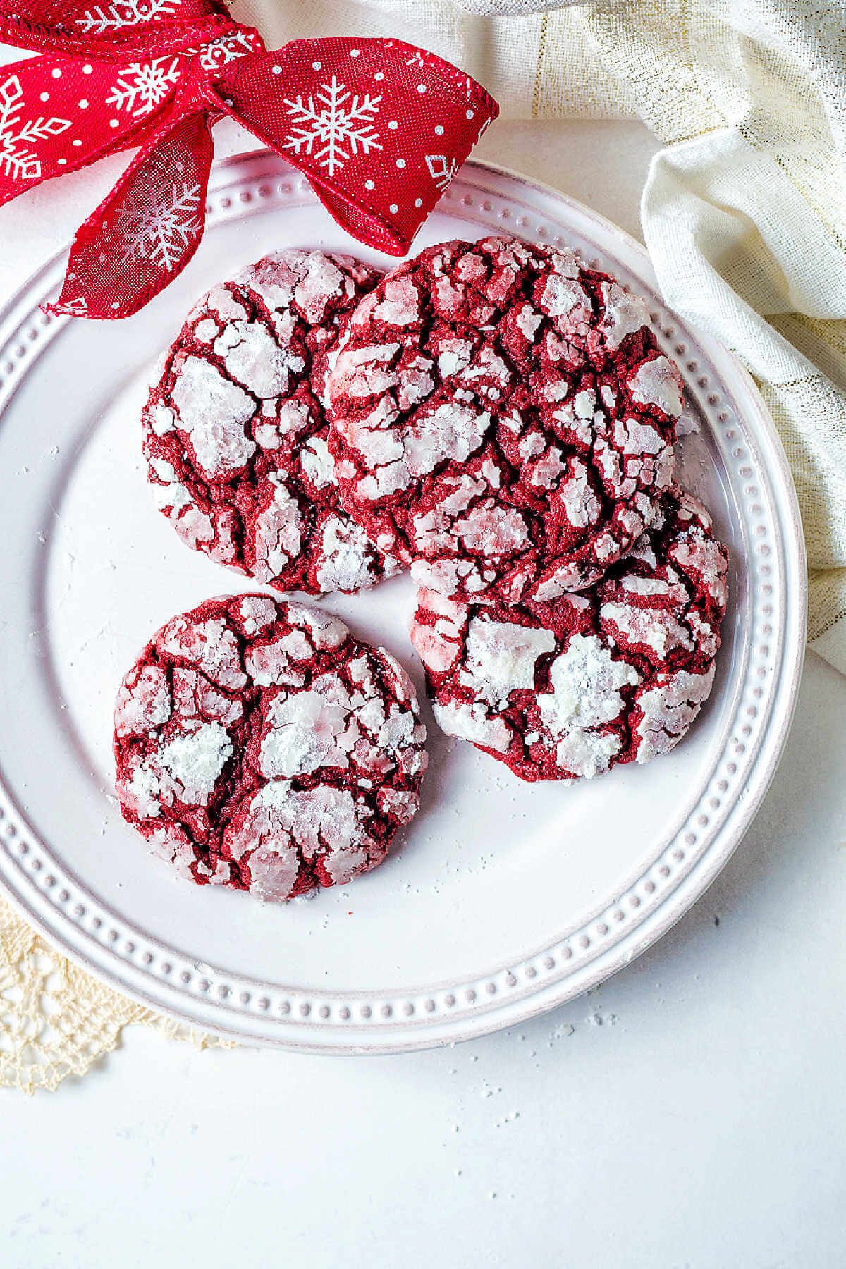 Overhead shot of red velvet cake crinkle cookies on a plate.
