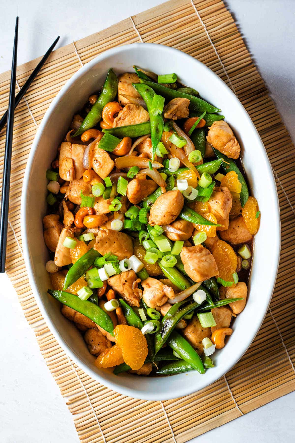 Chicken and cashew stir fry served in a serving dish with green onions on top.