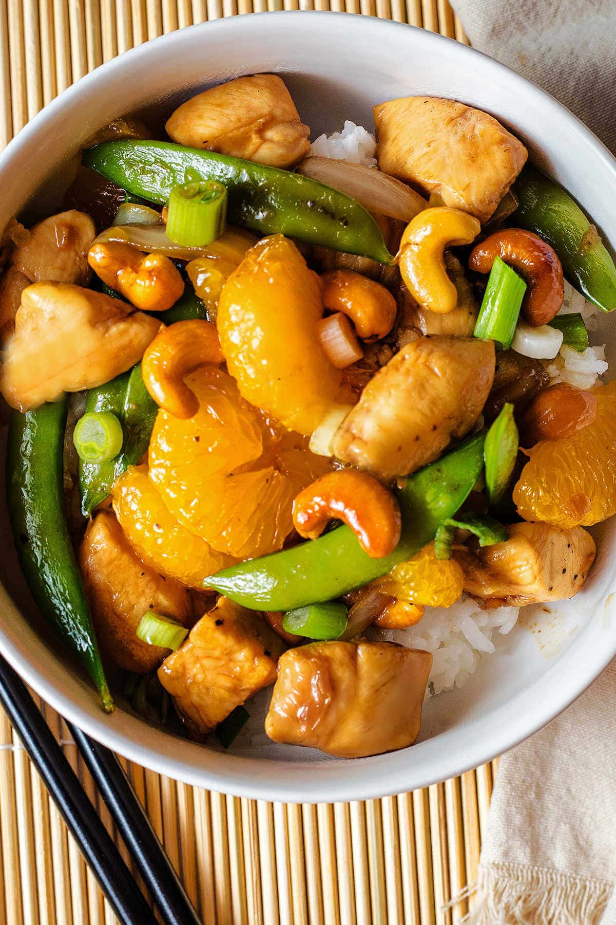 Bowl of rice with chicken and cashew stir fry on top.