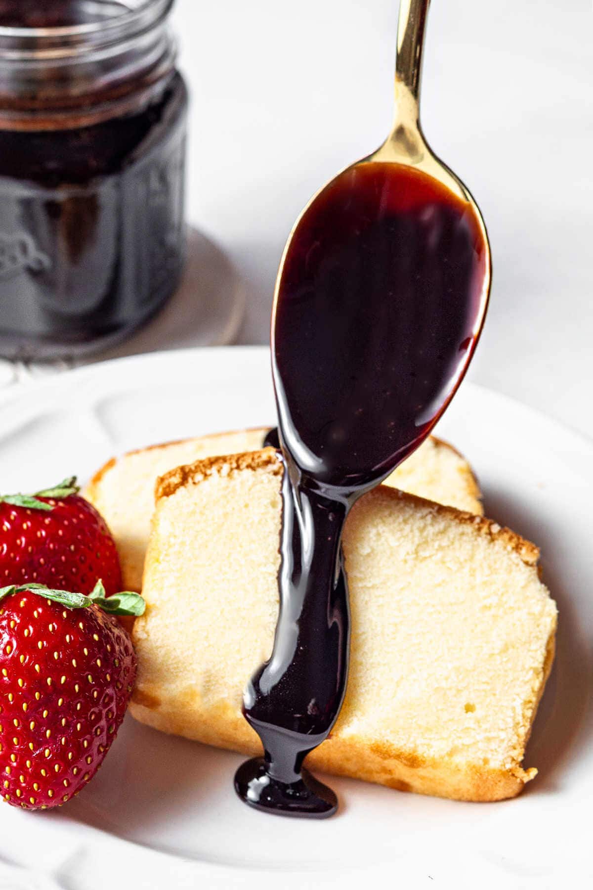 Spooning chocolate sauce over two slices of pound cake.