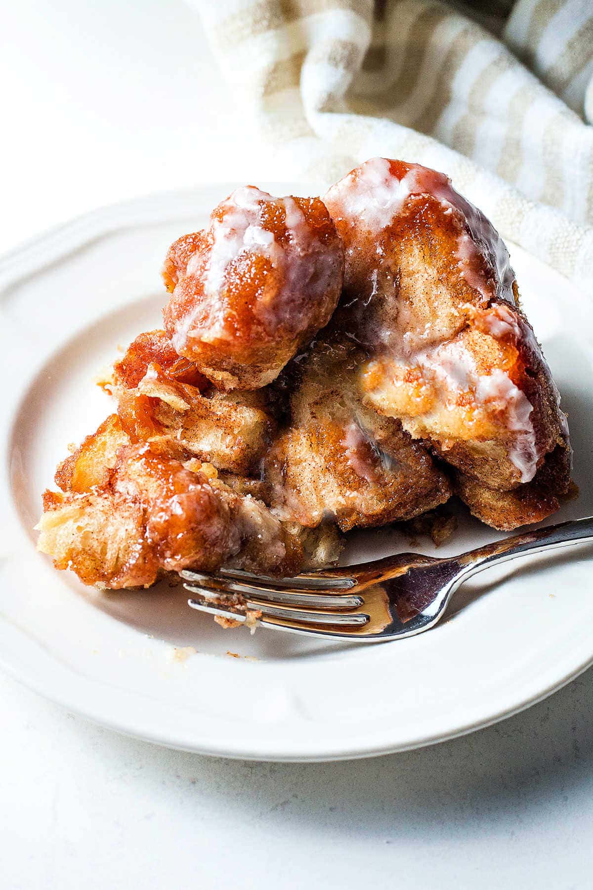 A serving of Monkey Bread on a plate with a fork.