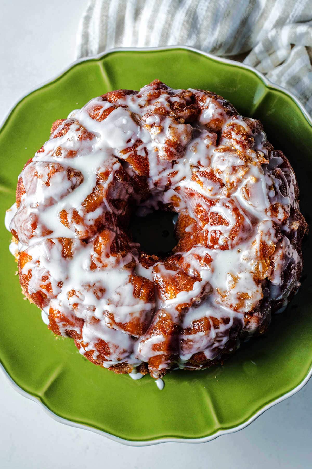 Glazed monkey bread with biscuits served on a green serving platter.