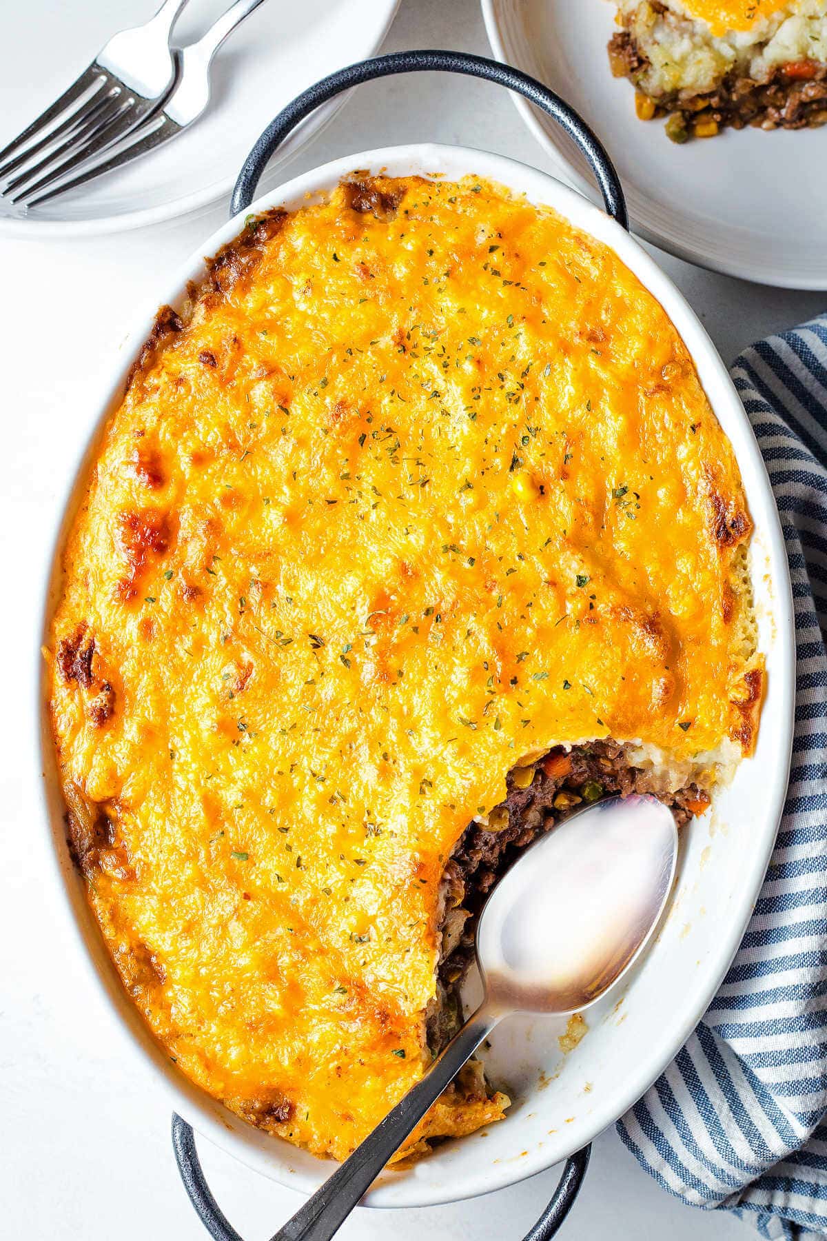 Shepherd's pie in a baking dish with a portion of it missing.