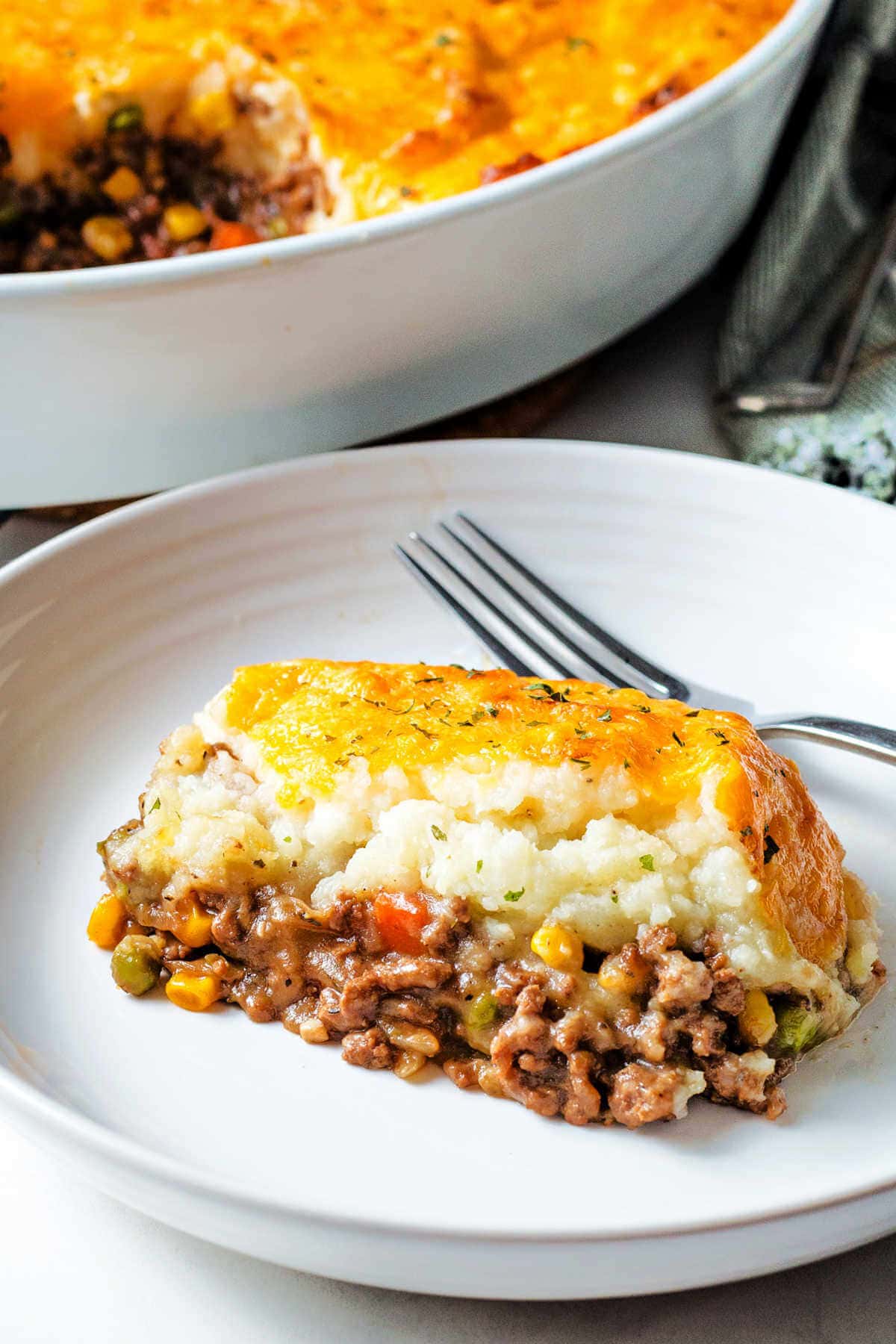 Portion of shepherd's pie on a plate with a fork.