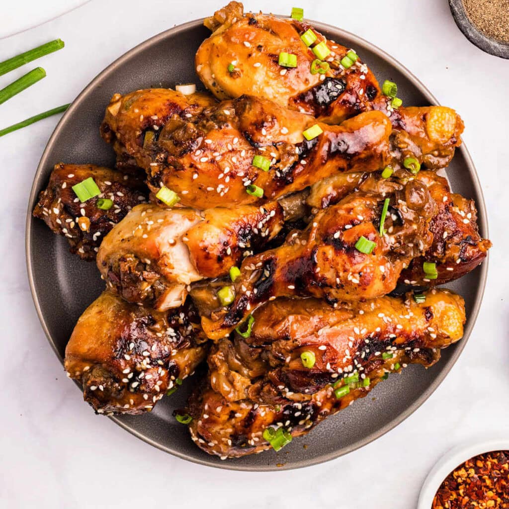 Slow Cooker Chicken Legs glazed with sticky honey sauce on a plate.