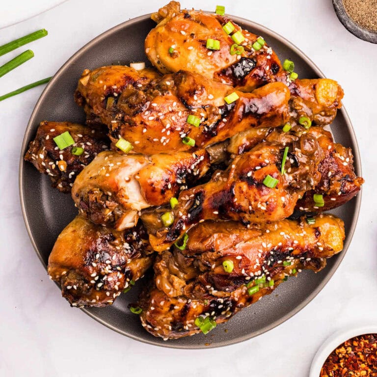 Slow Cooker Chicken Legs glazed with sticky honey sauce on a plate.