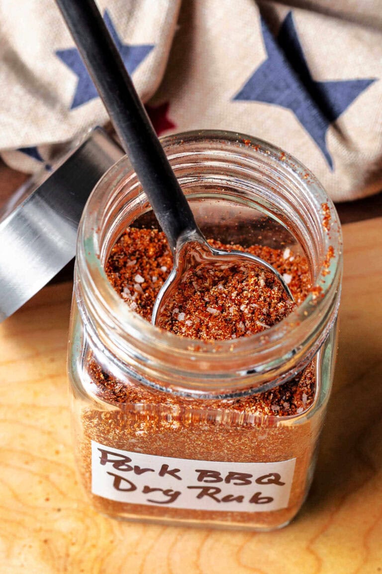 Pulled pork dry rub spices in a spice jar with a small spoon.