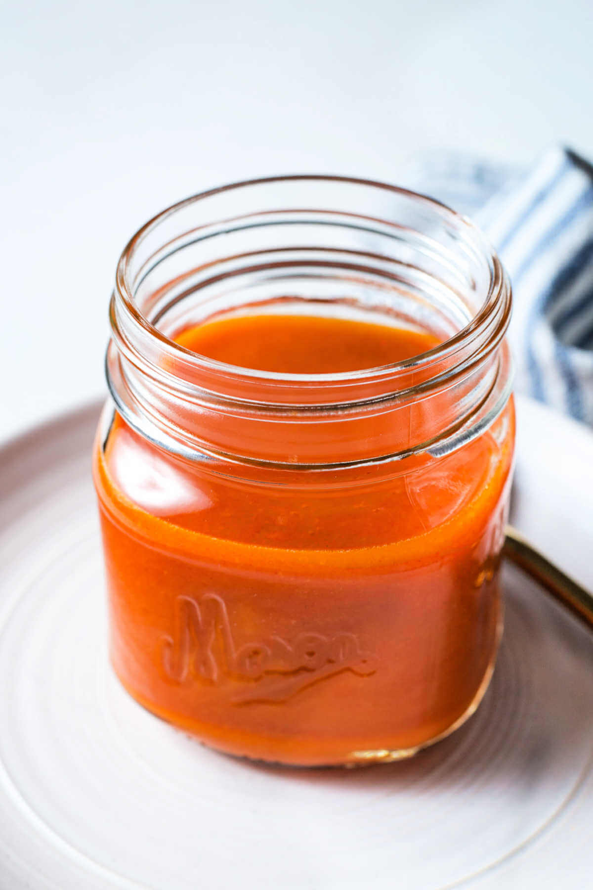 Buffalo chicken wing sauce in a jar on a plate.
