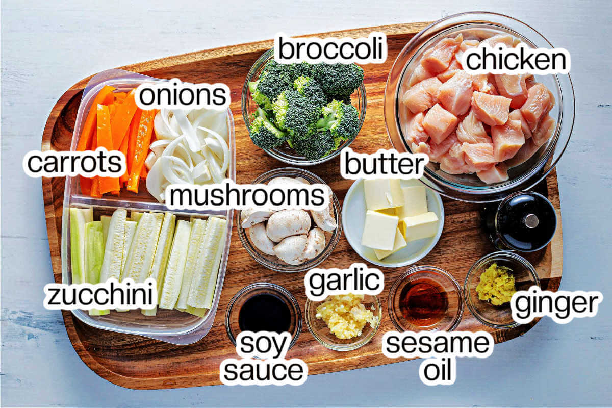 ingredients for hibachi chicken on a wooden tray on a table.