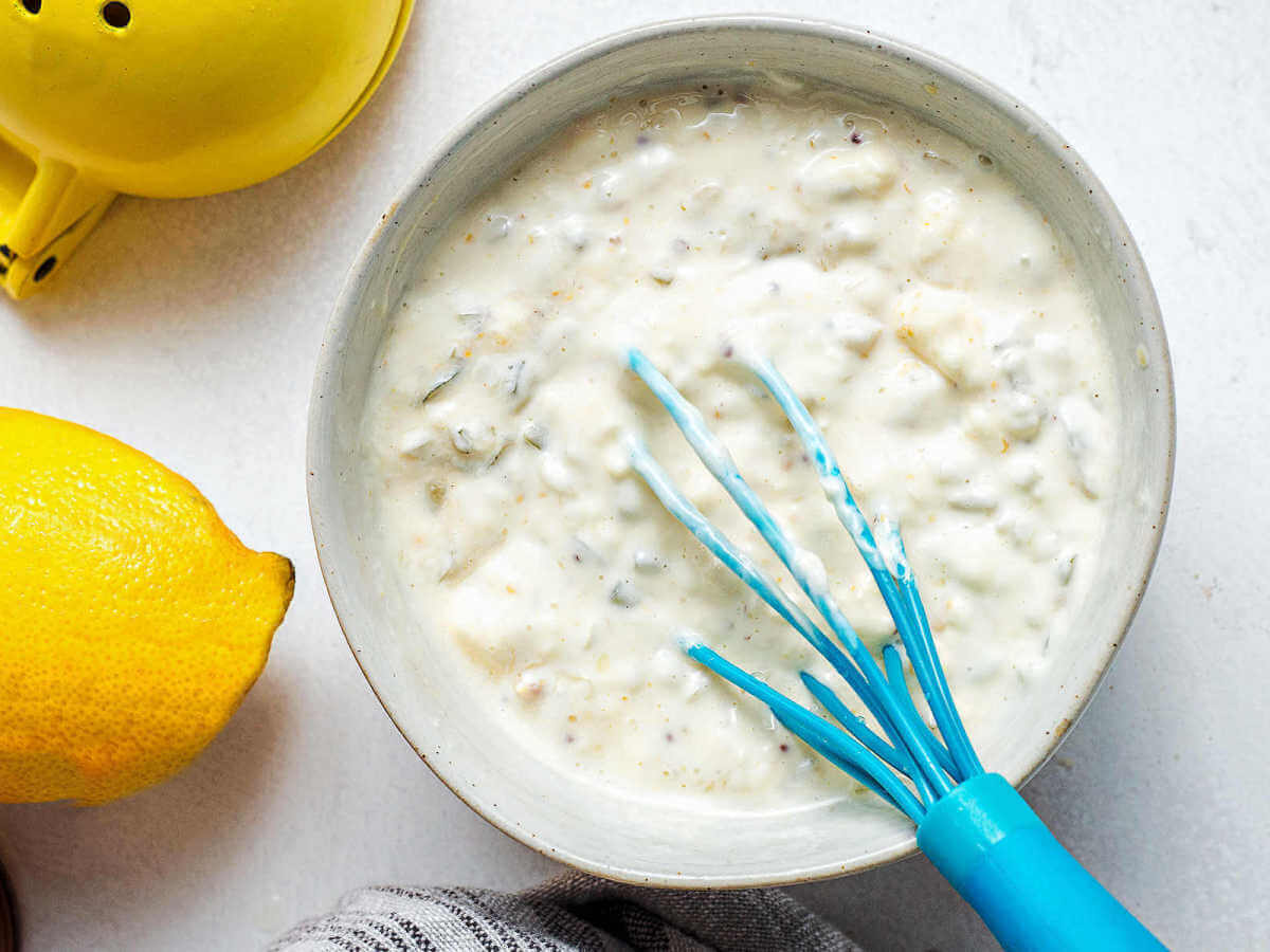 Whisking tartar sauce in a bowl.