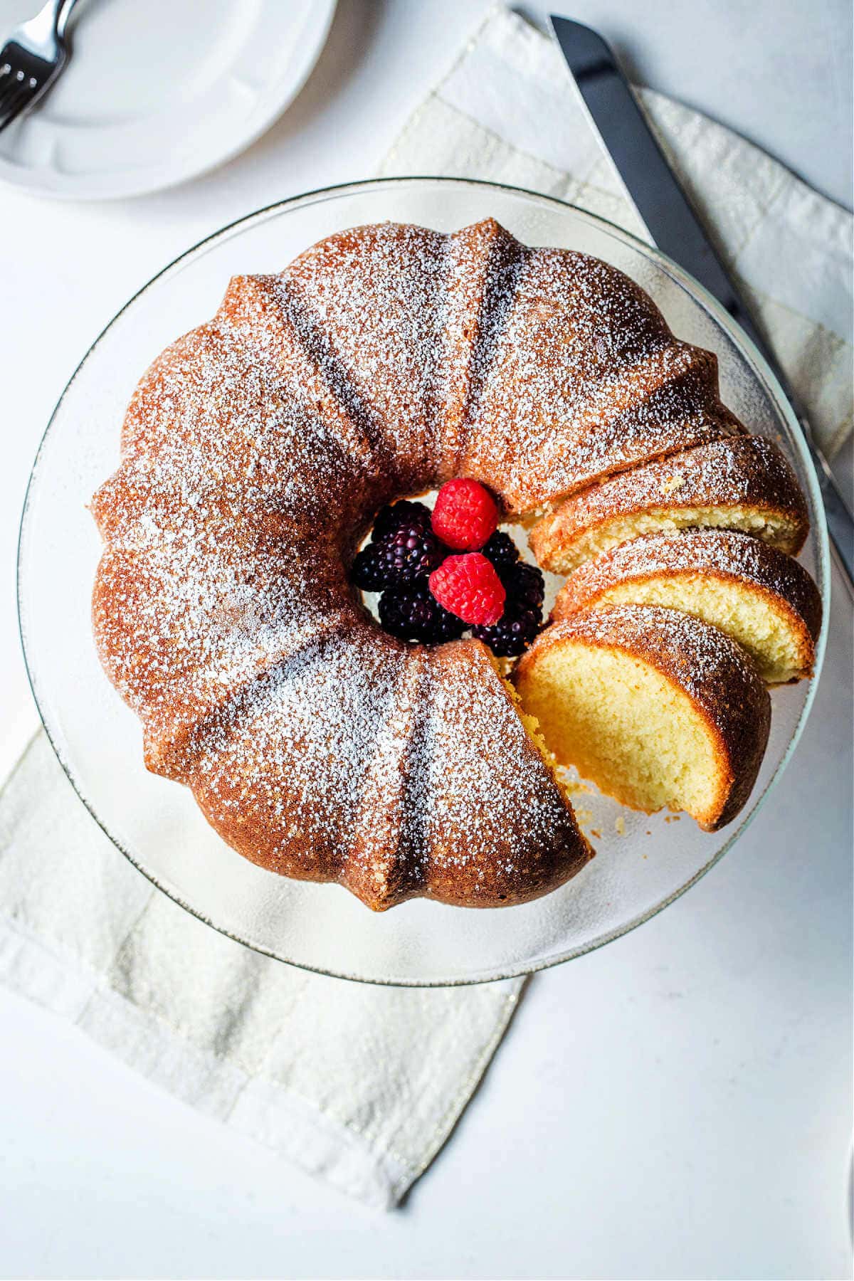 Pound cake sliced on a plate with some of the cake sliced.