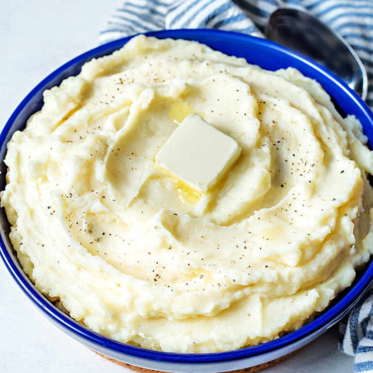 A bowl of instant pot mashed potatoes with apat of butter melting on top.