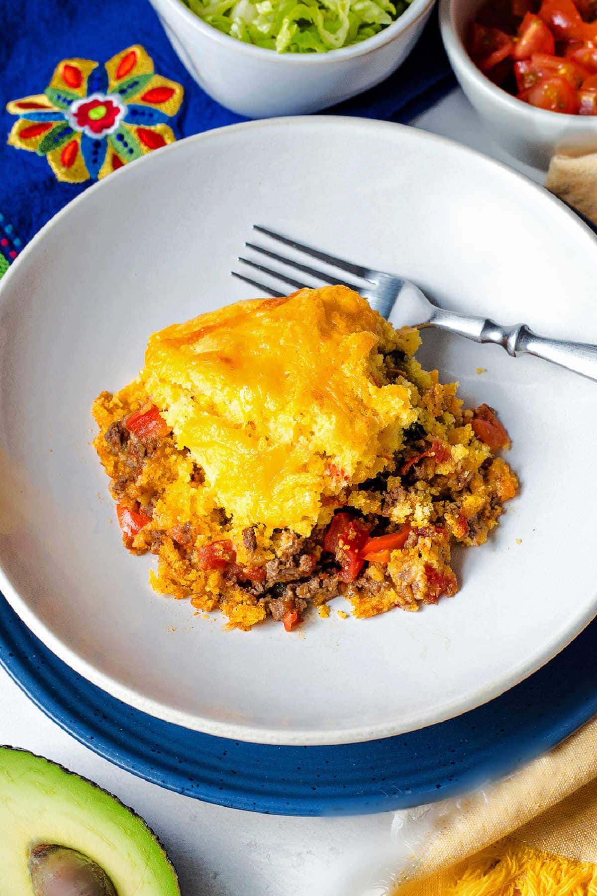 Portion of tamale pie served on a white plate with a fork.