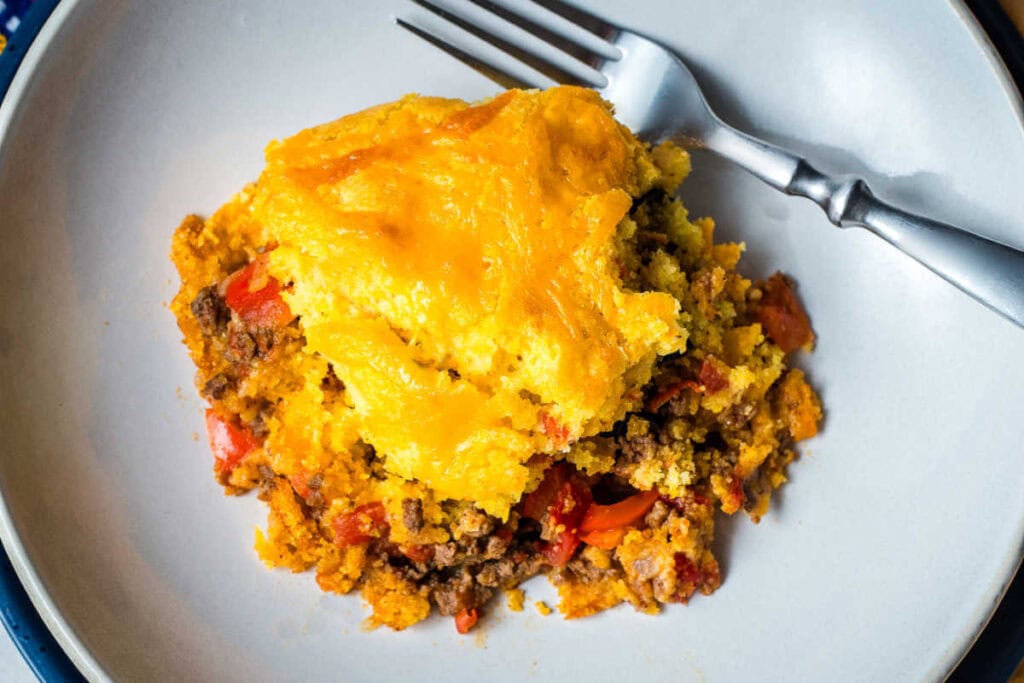 Close up of a portion of tamale pie in a bowl with a fork.