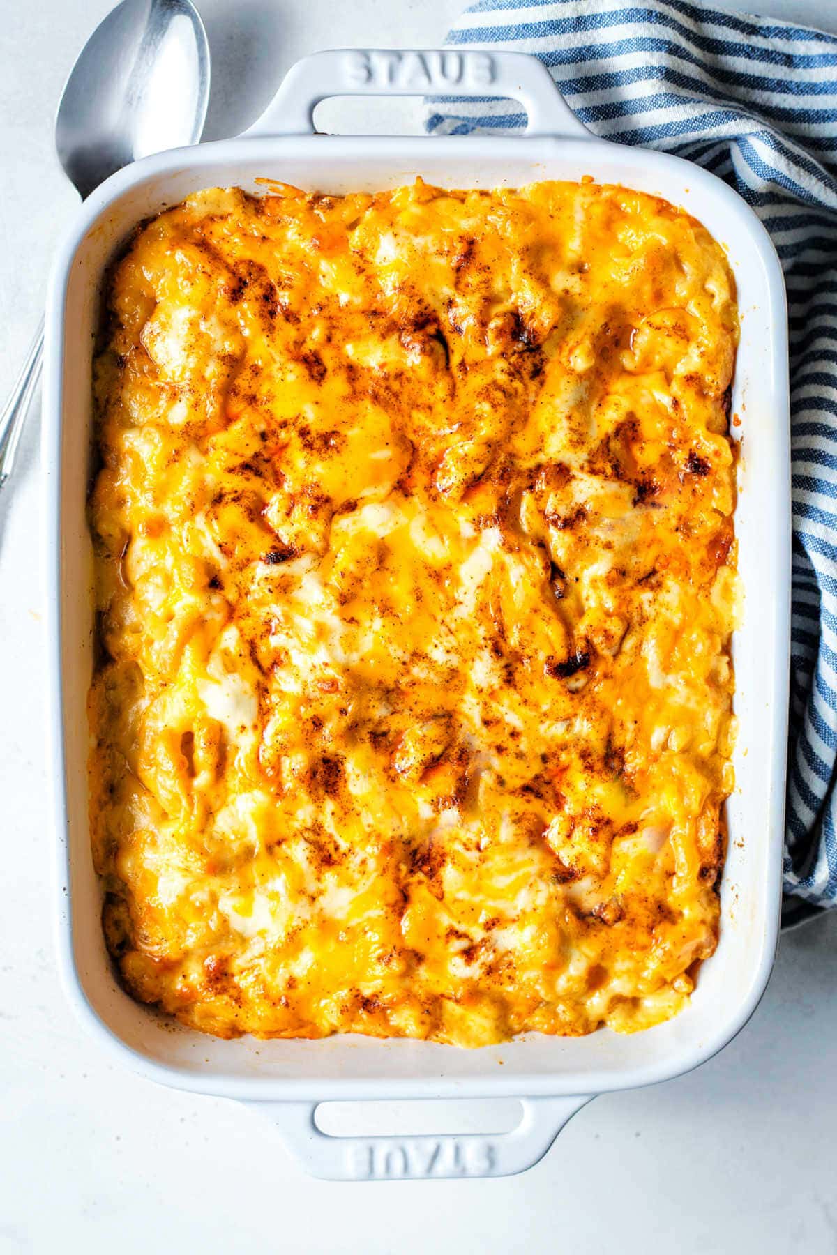 Finished baked macaroni and cheese in a white baking dish.
